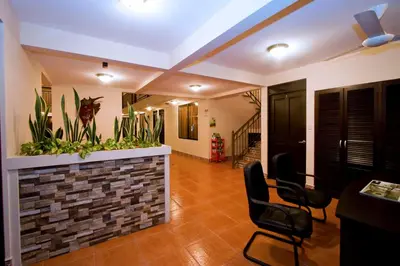 a living room with chairs and a wall with plants at Hotel El Cerro in Liberia