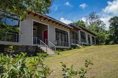 a house with a lawn in front of it at YerbaBuena Lodge in Monteverde Costa Rica
