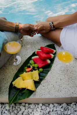 a plate of fruit on a table next to a pool at Samara Chillout Lodge - Adults only in Sámara