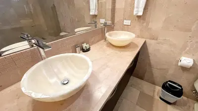 a bathroom with a white sink and a mirror at PACIFIC SUITES Boutique Hotel and Bistro in Jacó