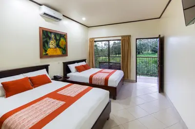 a bedroom with two beds and a balcony at Arenal Volcano Inn in Fortuna