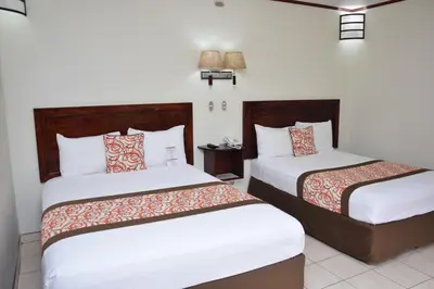 a hotel room with two beds with white and orange pillows at Arenal Volcano Inn in Fortuna