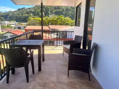 a patio with a table and chairs on a balcony at Nomada's Digital in Manuel Antonio
