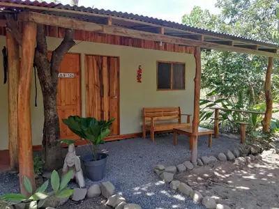 a small house with a bench and a table at El Gecko Hotel & Tours in Paquera