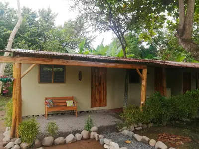 a house with a bench in front of it at El Gecko Hotel & Tours in Paquera