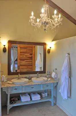 a bathroom with two sinks and a chandelier at Ocio Villas Mal Pais in Santa Teresa Beach