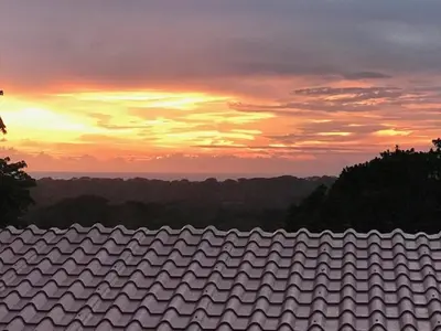a roof of a house with a sunset in the background at Villas Lambeau Ocean View 1 in Uvita
