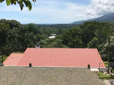 a red roof on top of a building with a view at Villas Lambeau Ocean View 1 in Uvita