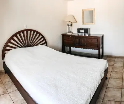 a bedroom with a bed and a dresser with a lamp at BL10 Bahia Langosta On the Beach 1bed+1bath in Tamarindo