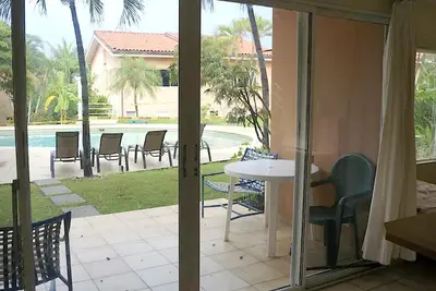 a patio with a table and chairs and a pool at BL10 Bahia Langosta On the Beach 1bed+1bath in Tamarindo