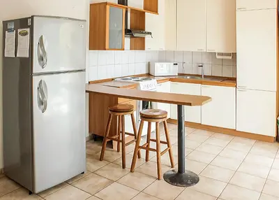a kitchen with a refrigerator and a table and stools at BL10 Bahia Langosta On the Beach 1bed+1bath in Tamarindo