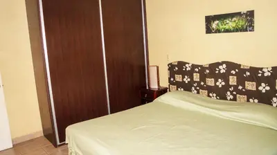 a bedroom with a bed and a wooden door at LC4 La Cometa Center of Tamarindo 1bed+1bath in Tamarindo
