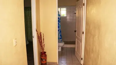 a bathroom with a toilet and a window and a doorway at LC4 La Cometa Center of Tamarindo 1bed+1bath in Tamarindo