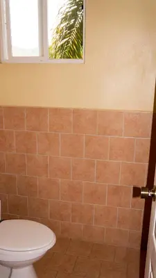 a bathroom with a toilet and a window at LC18 Cometa18 Center of Tamarindo 2bed 3bath in Tamarindo
