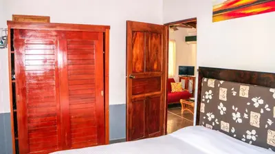 a bedroom with a bed and a wooden door at CWC Casa Wasabi 1bedroom 1bathroom in Tamarindo