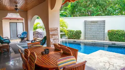a patio with a table and chairs next to a swimming pool at CW3 Casa Wasabi 3bed+3bath in Tamarindo
