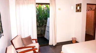 a room with a bed and a chair and a window at CW3 Casa Wasabi 3bed+3bath in Tamarindo