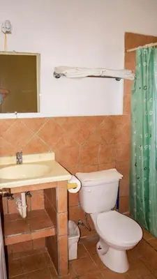 a bathroom with a toilet and a sink and a mirror at LC17 La Cometa Center of Tamarindo 2bed+2.5bath in Tamarindo
