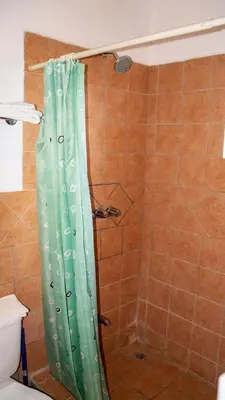 a shower with a green shower curtain in a bathroom at LC17 La Cometa Center of Tamarindo 2bed+2.5bath in Tamarindo