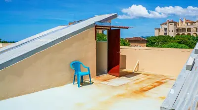 a blue chair sitting on the roof of a building at LC17 La Cometa Center of Tamarindo 2bed+2.5bath in Tamarindo