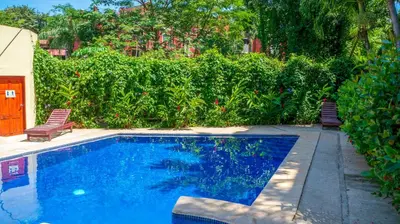 a swimming pool in a yard with two chairs at LC17 La Cometa Center of Tamarindo 2bed+2.5bath in Tamarindo