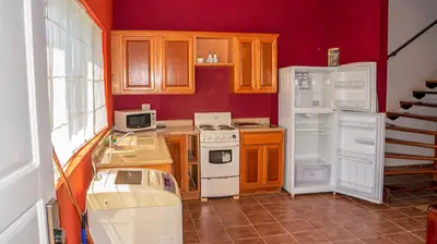 a kitchen with a white stove and a refrigerator at LC17 La Cometa Center of Tamarindo 2bed+2.5bath in Tamarindo