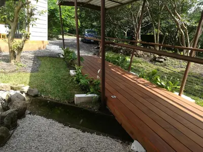 a wooden deck with plants on the side of a house at Hotel Pibi Boreal in Alajuela City