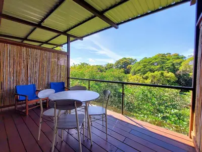 a porch with a table and chairs on a deck at Hotel Pibi Boreal in Alajuela City