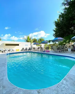 a large blue swimming pool with chairs and umbrellas at Hotel Las Palmas de OSA in Ciudad Cortés