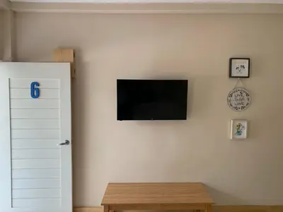 a flat screen tv on a white wall with a table at Hotel Las Palmas de OSA in Ciudad Cortés