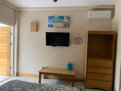 a living room with a tv and a wooden table at Hotel Las Palmas de OSA in Ciudad Cortés