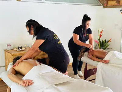 two women in a massage room with a man laying on a bed at Hotel Luna Llena in Tamarindo