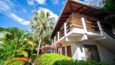 a building with palm trees in front of it at Hotel Luna Llena in Tamarindo