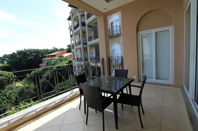 a balcony with a table and chairs on a balcony at Matapalo Diria #504 Amazing Condo-Ocean View in Tamarindo