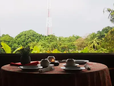a table with plates and candles on a table with a window at Hotel Belvedere Playa Samara Costa Rica in Sámara
