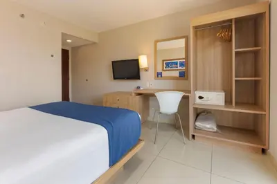 a bedroom with a bed and a desk and a television at City Express by Marriott San José Costa Rica in San José