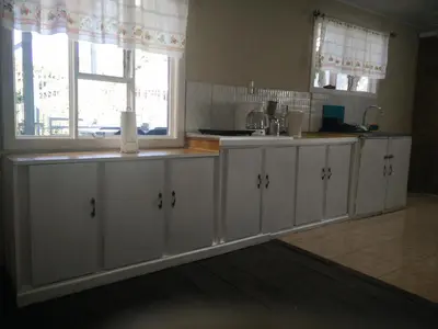 a kitchen with white cabinets and a window at Casa Chayito in Santa María