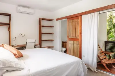 a bedroom with a bed and a desk and a window at Outsite Santa Teresa Playa in Santa Teresa Beach