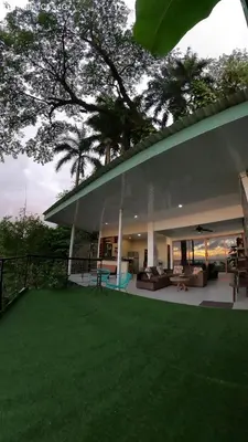 a house with a green lawn in front of it at Casa Federico in Quepos