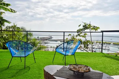 two blue chairs on a balcony with a bowl of food at Casa Federico in Quepos