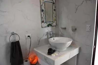 a white bathroom with a sink and a mirror at Casa Federico in Quepos