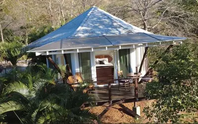 a gazebo with a blue roof on a deck at Mikado Natural Lodge in Playa Avellana