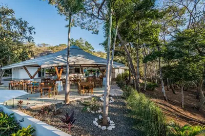 a tent with tables and chairs in the trees at Mikado Natural Lodge in Playa Avellana