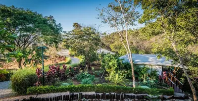 a garden in front of a house at Mikado Natural Lodge in Playa Avellana