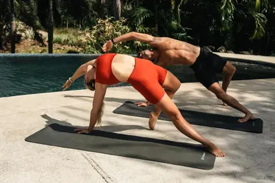 two people doing yoga next to a swimming pool at Mikado Natural Lodge in Playa Avellana