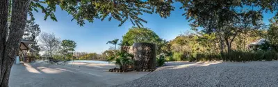 a park with a tree in the middle of a road at Mikado Natural Lodge in Playa Avellana