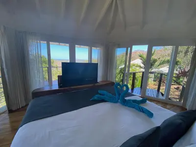 a bedroom with a bed with a blue ribbon on it at Mikado Natural Lodge in Playa Avellana