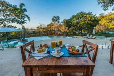 a wooden table with a plate of fruit on it at Mikado Natural Lodge in Playa Avellana