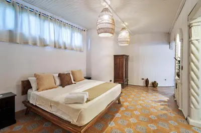 a bedroom with a large bed and two pendant lights at Paradise Beach Lodge in Mal País
