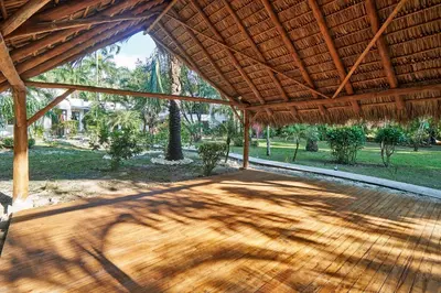 a large wooden pavilion with a wooden floor and a wooden roof at Paradise Beach Lodge in Mal País